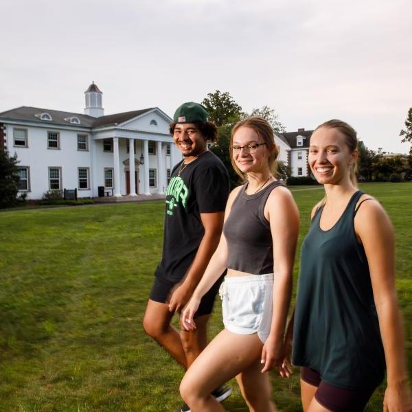 Three students from the College Tour are walking toward the life sciences building